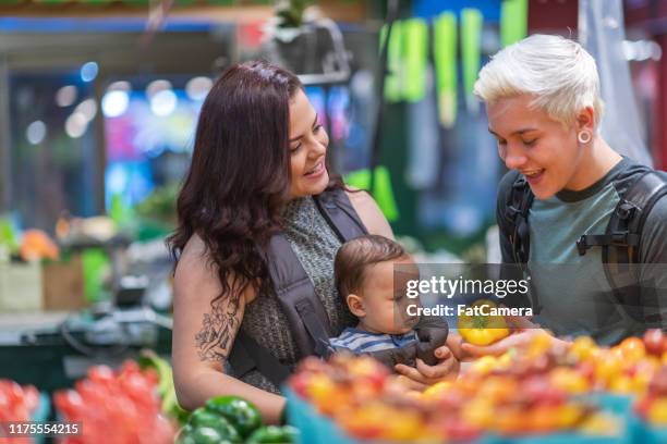 jungelgbt-paar mit baby-shopping im lebensmittelgeschäft - couple in supermarket stock-fotos und bilder