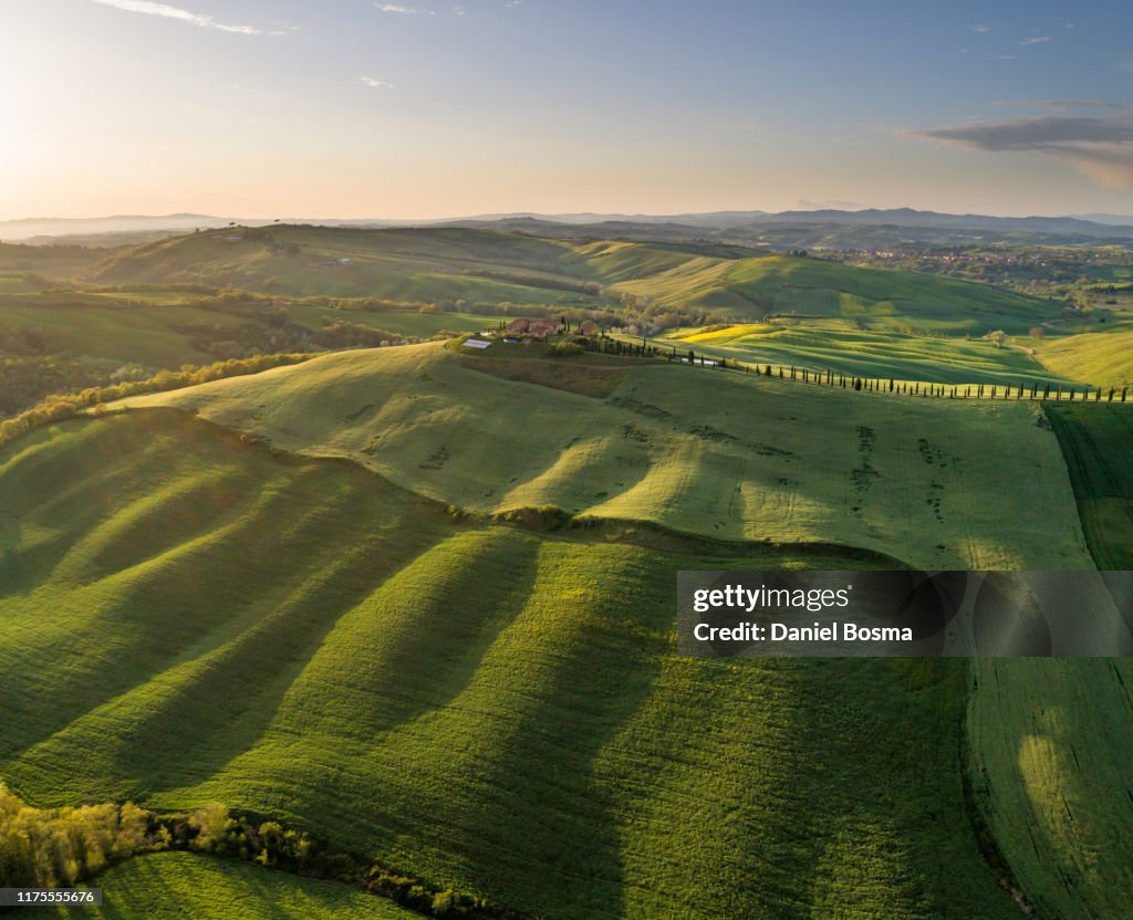 Sunlit rolling landscape in Tuscany bathing in late afternoon sunlight and seen from the air
