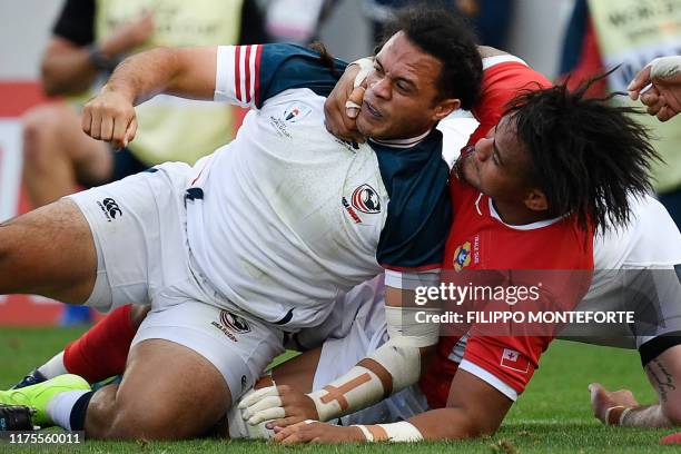 Tonga's lock Leva Fifita tackles US full back Mike Teo during the Japan 2019 Rugby World Cup Pool C match between the United States and Tonga at the...