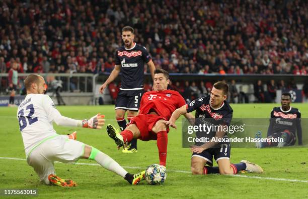 Robert Lewandowski of FC Bayern Munich scores his sides first goal past Milan Borjan of Crvena Zvezda under pressure from Marko Gobelijic of Crvena...