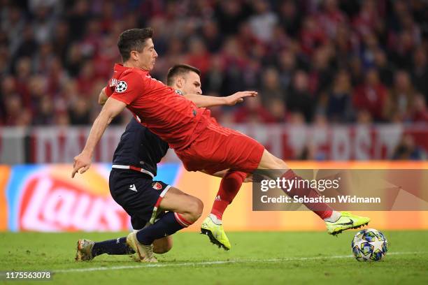 Robert Lewandowski of FC Bayern Munich scores his sides first goal past Milan Borjan of Crvena Zvezda under pressure from Marko Gobelijic of Crvena...