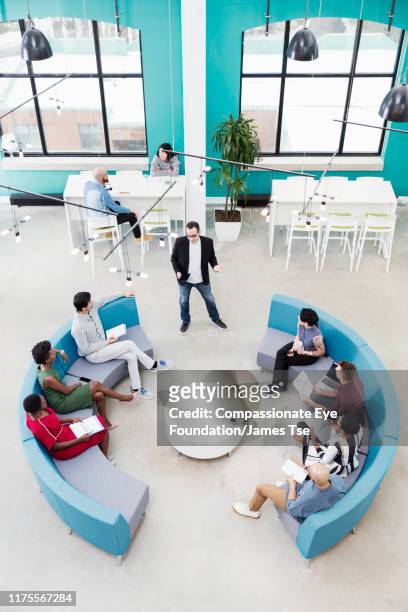 businessman leading informal meeting in modern open plan office - cef do not delete stock pictures, royalty-free photos & images