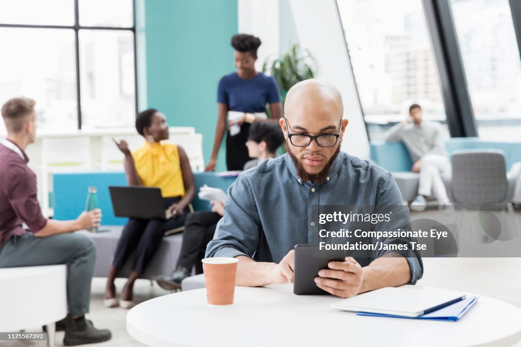 Businessman using digital tablet in modern open plan office