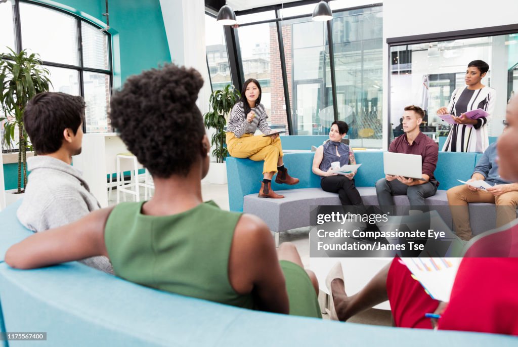 Businesswoman leading informal meeting in modern open plan office