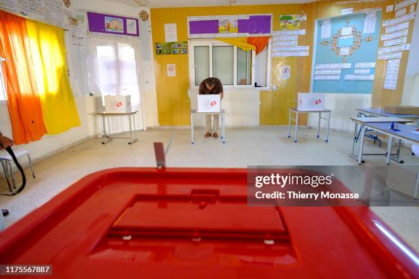 Woman casts her ballot at a polling station during the second round of the presidential election on October 13, 2019 in Tunis, Tunisia. The...