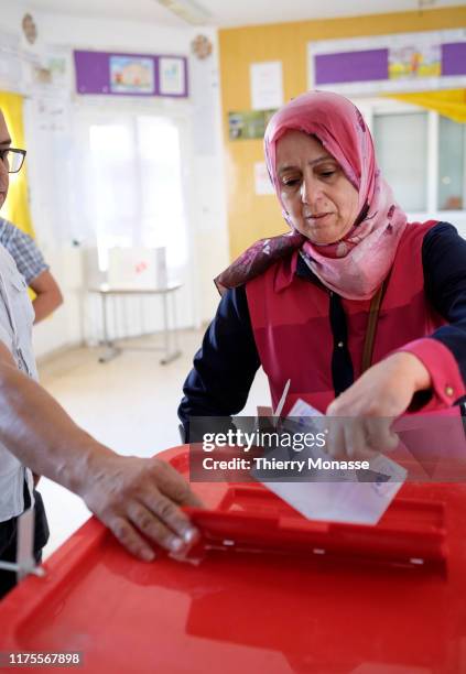 Woman casts her ballot at a polling station during the second round of the presidential election on October 13, 2019 in Tunis, Tunisia. The...