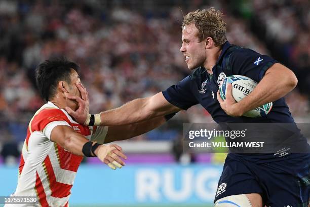 Scotland's lock Jonny Gray fends off a Japan player during the Japan 2019 Rugby World Cup Pool A match between Japan and Scotland at the...