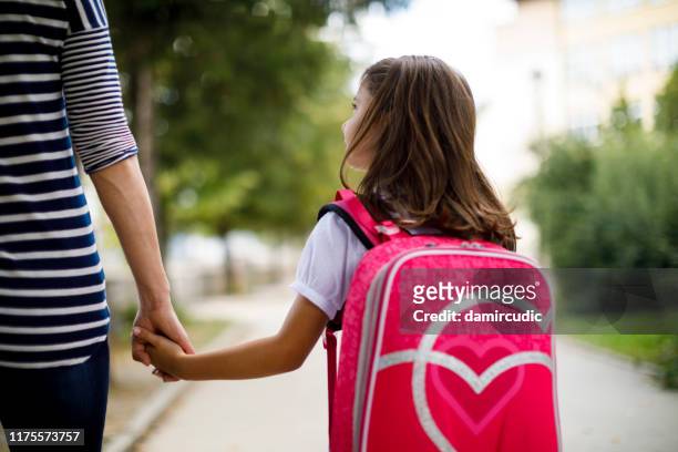 mother taking her daughter to school - leaving school imagens e fotografias de stock