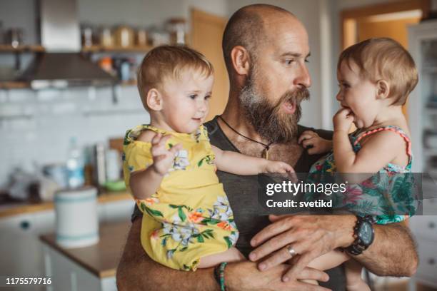 tijd doorbrengen met vader - eeneiige tweeling stockfoto's en -beelden