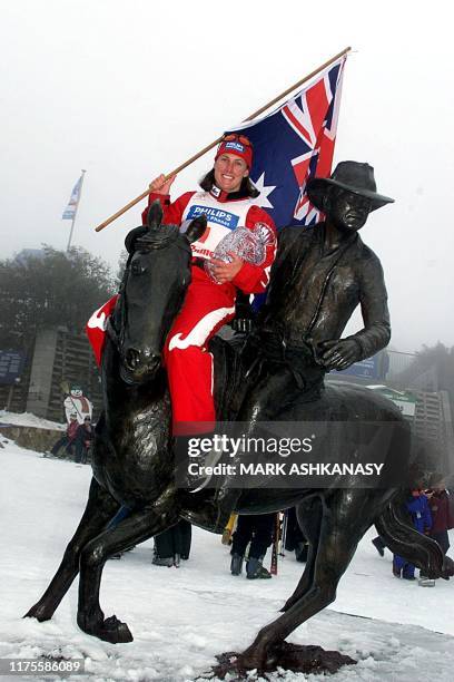 Reigning FIS Freestyle World Cup champion, Jacqui Cooper from Australia holding her national flag, sits on a bushman and horse statue representing...