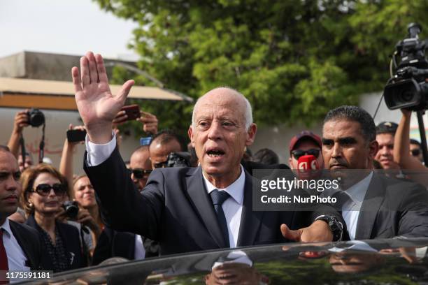 Kais Saied, professor of constitutional law and presidential candidate, greets people as he leaves the polling station after casting his vote for the...