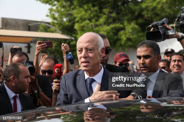 Kais Saied, professor of constitutional law and presidential candidate, greets people as he leaves the polling station after casting his vote for the...