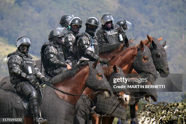 Ecuadorean riot policemen stand guard following a 10-day protest over a fuel price hike ordered by the government to secure an IMF loan, in Quito on...