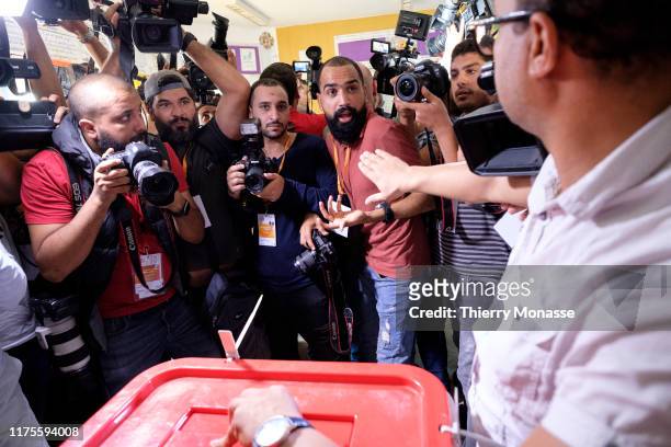 Photographers and cameramen jostle for position as the Tunisian presidential candidate, Media mogul Nabil Karoui casts his ballot during the second...