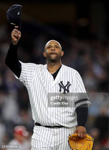 Sabathia of the New York Yankees salutes the fans as he is pulled from the game in the third inning against the Los Angeles Angels at Yankee Stadium...