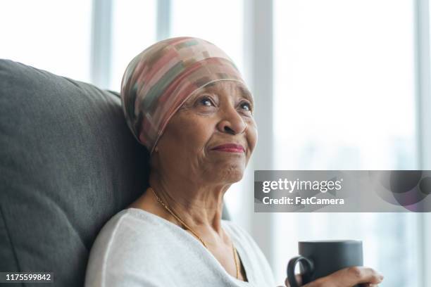 portret van een contemplatieve senior vrouw met kanker - headscarf home stockfoto's en -beelden
