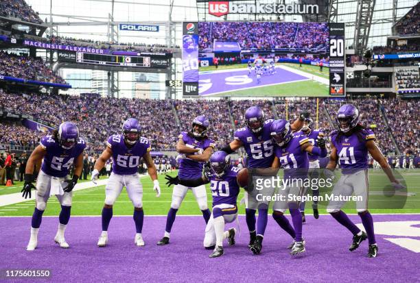 Mackensie Alexander of the Minnesota Vikings celebrates with teammates after intercepting the ball in the fourth quarter of the game against the...