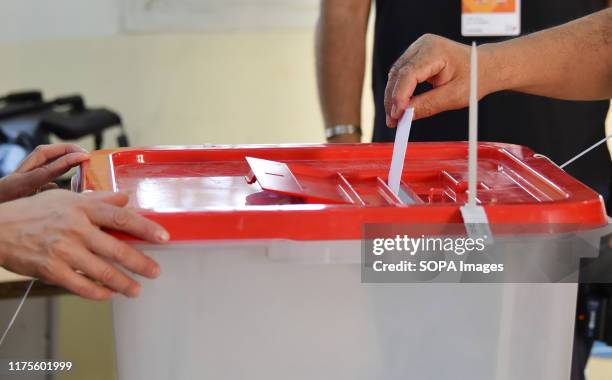 Tunisian voter casts her ballot at a polling station during the second round of the presidential election. Voters will choose between law professor...