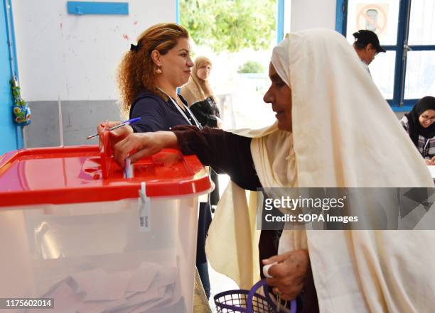 Tunisian voter casts her ballot at a polling station during the second round of the presidential election. Voters will choose between law professor...