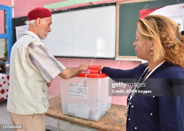Tunisians voters cast their ballot at a polling station during the second round of the presidential election. Voters will choose between law...
