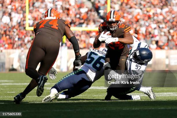 Nick Chubb of the Cleveland Browns is tackled by Mychal Kendricks of the Seattle Seahawks and Poona Ford during the fourth quarter at FirstEnergy...