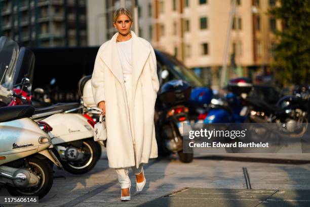 Caroline Daur a white coat, a white bag, a white t-shirt, pants, heels shoes, outside the Alberta Ferretti show during Milan Fashion Week...