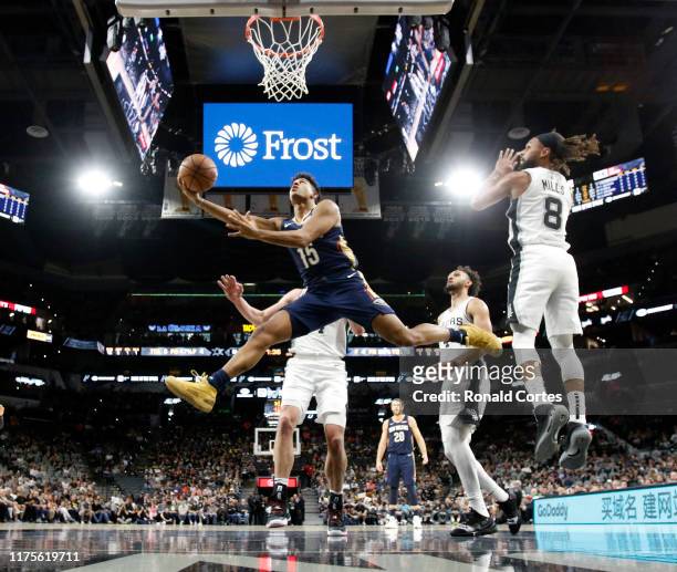 Frank Jackson of the New Orleans Pelicans drives past San Antonio Spurs defenders in preseason game at AT&T Center on October 13 , 2019 in San...