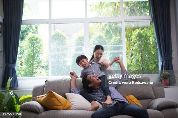 family playing together father giving his son piggyback ride happiness time together at home - action hero foto e immagini stock