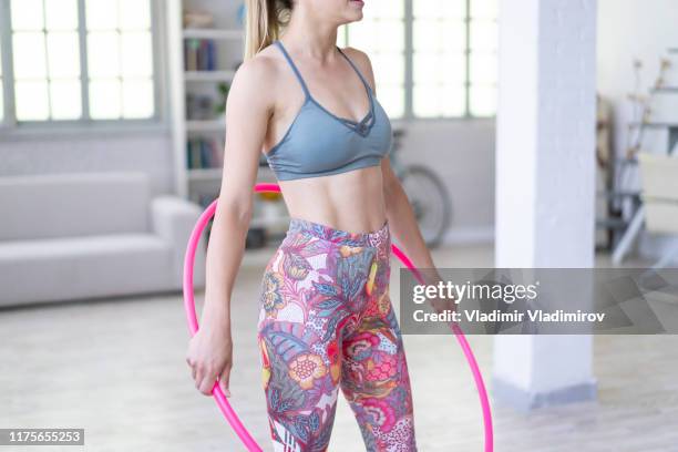 woman holding a plastic hoop and practicing at home - hula hoop studio stock pictures, royalty-free photos & images