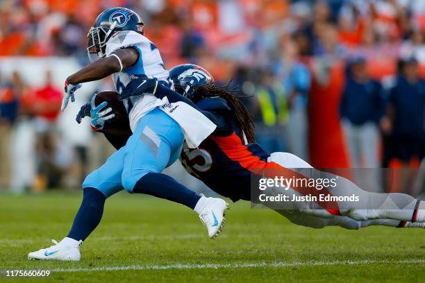 Linebacker A.J. Johnson of the Denver Broncos tackles running back Dion Lewis of the Tennessee Titans during the fourth quarter at Empower Field at...