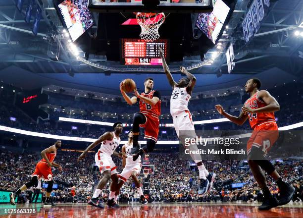 Zach LaVine of the Chicago Bulls goes to the basket against Chris Boucher of the Toronto Raptors during their NBA basketball preseason game at...