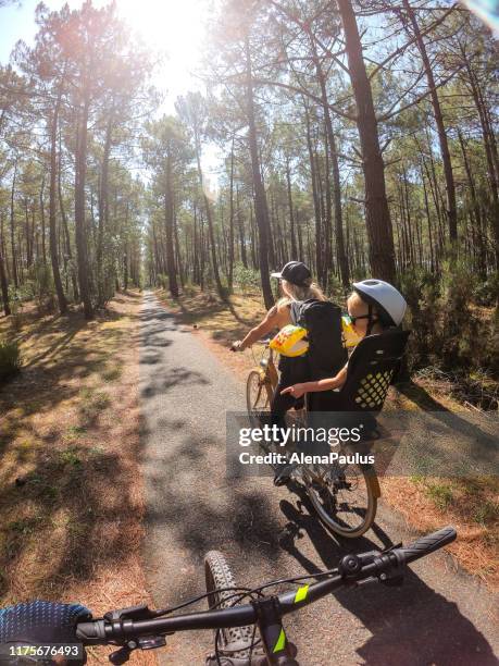 family cycling through the forest to the beach at the ocean - saddle bag stock pictures, royalty-free photos & images