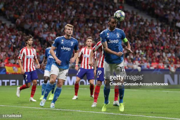 Captain Leonardo Bonucci of Juventus saves on a header ahead Diego Costa of Atletico de Madrid during the UEFA Champions League group D match between...
