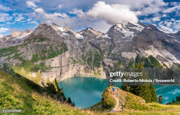 hikers at oeschinensee lake, bernese oberland, switzerland - berner alpen stock-fotos und bilder