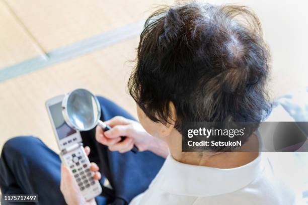 grandmother reading the letter on the phone - presbyopia stock pictures, royalty-free photos & images