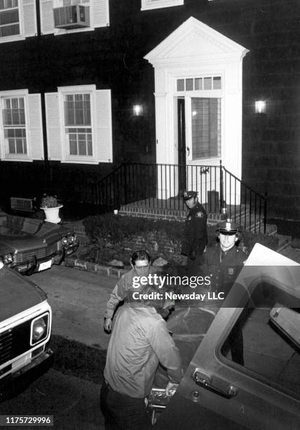 Suffolk County Medical Examiner driver places one of the bodies out of the DeFeo home located at 112 Ocean Avenue in Amityville, New York, where six...