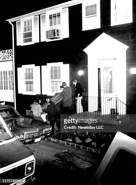 Suffolk County Medical Examiner personnel remove bodies from the DeFeo home located at 112 Ocean Avenue in Amityville, New York, where six members of...