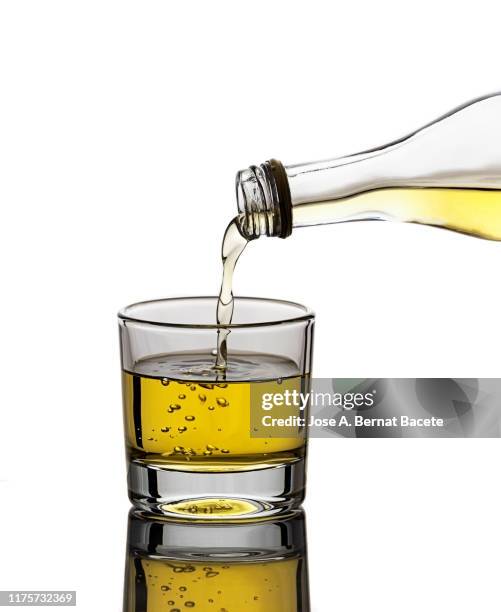 glass of crystal of chupito fill of an alcoholic drink, filling them with a bottle of drink, (shot of spirit). - empty fridge studio stock pictures, royalty-free photos & images