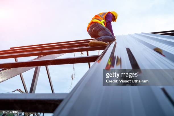 roofer worker in special protective workwear - house roof materials stock pictures, royalty-free photos & images