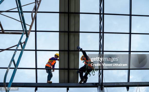 construction worker on rooftop - scaffolding industrial stock pictures, royalty-free photos & images