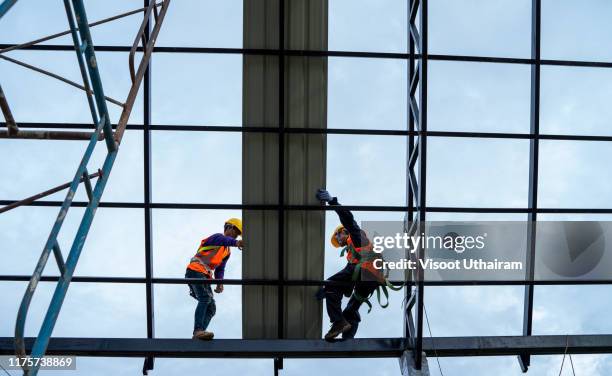 construction worker on rooftop - metal hammer stock pictures, royalty-free photos & images