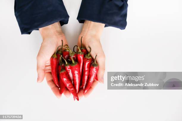 pods of red hot chili pepper in the hands of a woman on a white background. homemade vegetables in the palms of the girl. - i was turning into a vegetable stock pictures, royalty-free photos & images