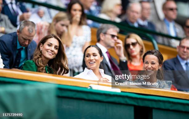 Catherine, Duchess of Cambridge talks with Meghan, Duchess of Sussex and Pippa Middleton in the royal box before the start of the Women's Singles...