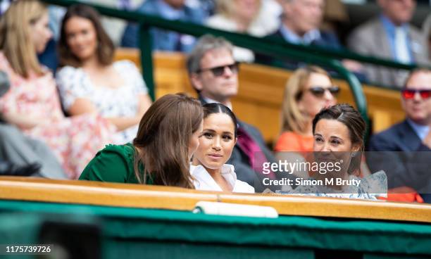 Catherine, Duchess of Cambridge talks with Meghan, Duchess of Sussex and Pippa Middleton in the royal box before the start of the Women's Singles...