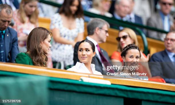 Catherine, Duchess of Cambridge talks with Meghan, Duchess of Sussex and Pippa Middleton in the royal box before the start of the Women's Singles...