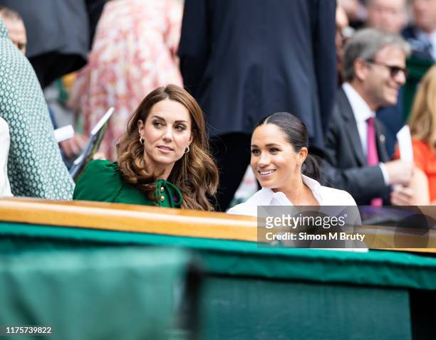 Catherine, Duchess of Cambridge talks with Meghan, Duchess of Sussex in the royal box before the start of the Women's Singles Final between Simona...