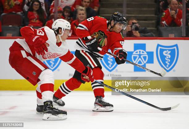 Patrick Kane of the Chicago Blackhawks shoots past Moritz Seider of the Detroit Red Wings during a preseason game at the United Center on September...