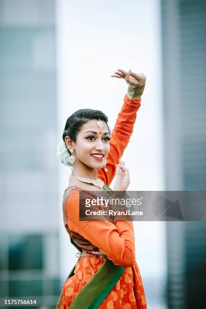 indian woman dancing in traditional clothing downtown city setting - traditional dancing stock pictures, royalty-free photos & images