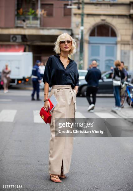 Viktoria Rader is seen wearing beige skirt, red bag, black blouse, laced, sandals outside the Max Mara show during Milan Fashion Week Spring/Summer...
