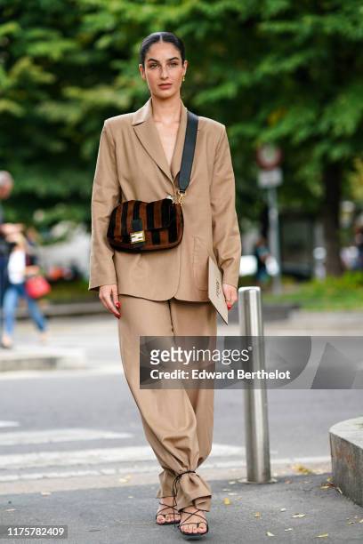 Fiona Zanetti wears a light brown blazer jacket, pants, a brown striped fluffy Fendi bag, outside the Fendi show during Milan Fashion Week...